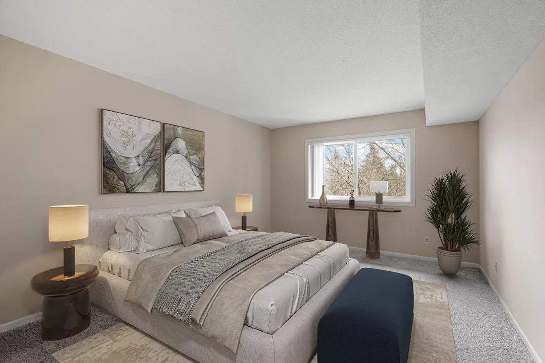 Bright, modern bedroom with a king bed, neutral bedding, bedside tables, wall art, and a window view of trees.